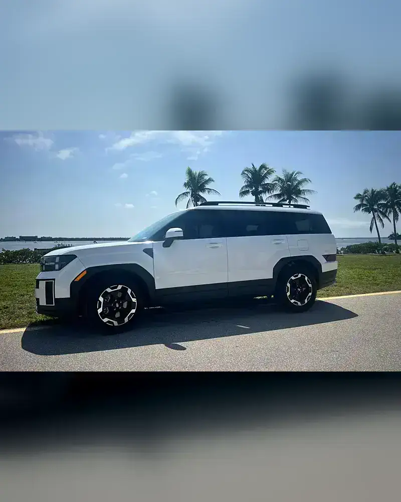 A 2024 Hyundai Santa Fe from the SWFL Auto Rentals fleet, parked on a paved road by the Gulf