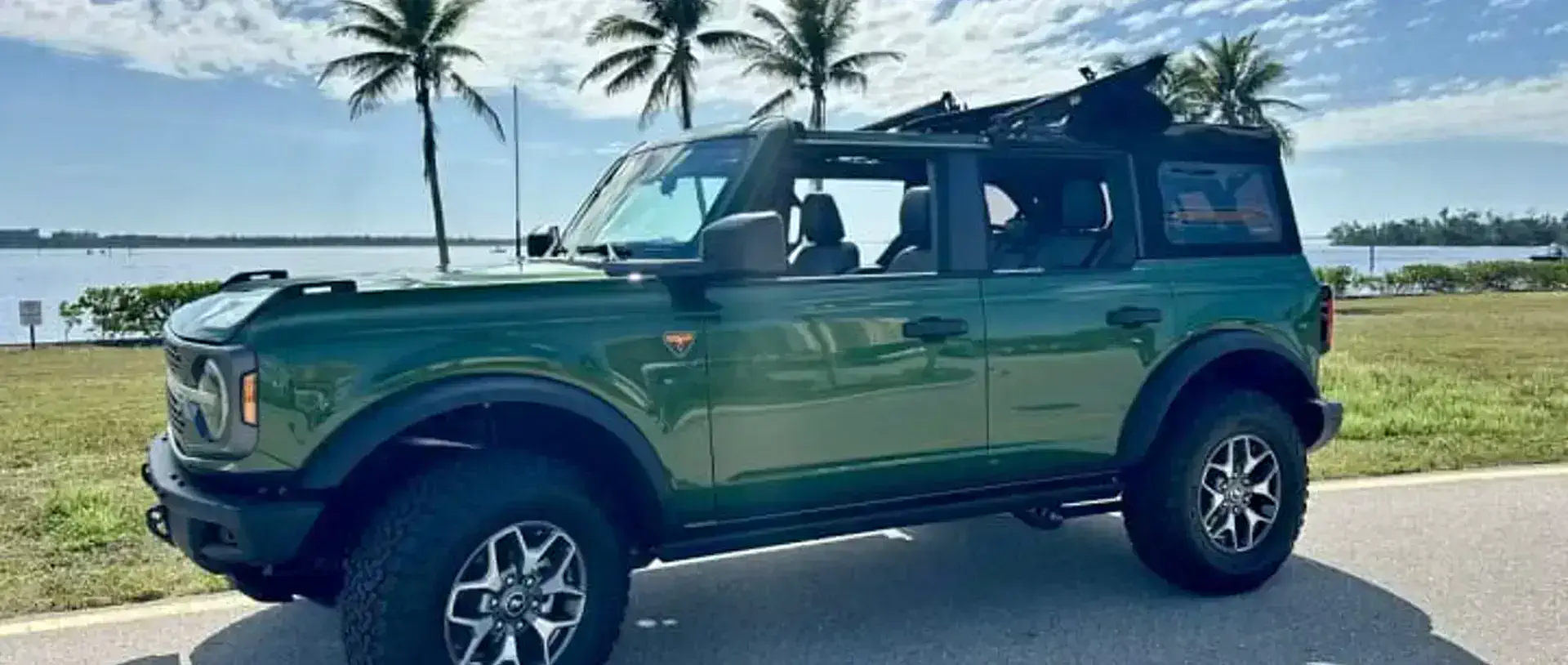 A 2024 Ford Bronco from the SWFL Auto Rentals fleet on a coastal road in Southwest Florida